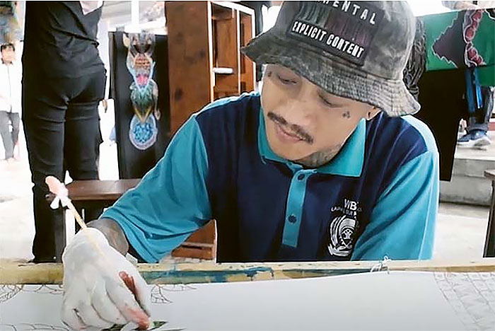 JAGO DESAIN:  Ichwanul  Muzaki  membuat  desain batik  motif koi di  blok bimker  Lembaga  pemasya rakatan  (Lapas)    Lowokwaru  kemarin (11/1).
