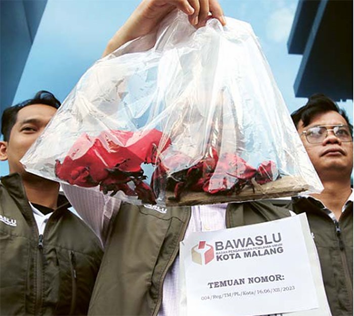 DIUSUT: Tim Bawaslu Kota Malang menunjukkan barang bukti sisa bendera yang dibakar saat melaporkan tindak pidana pemilu itu ke Polresta Malang Kota kemarin (12/1).