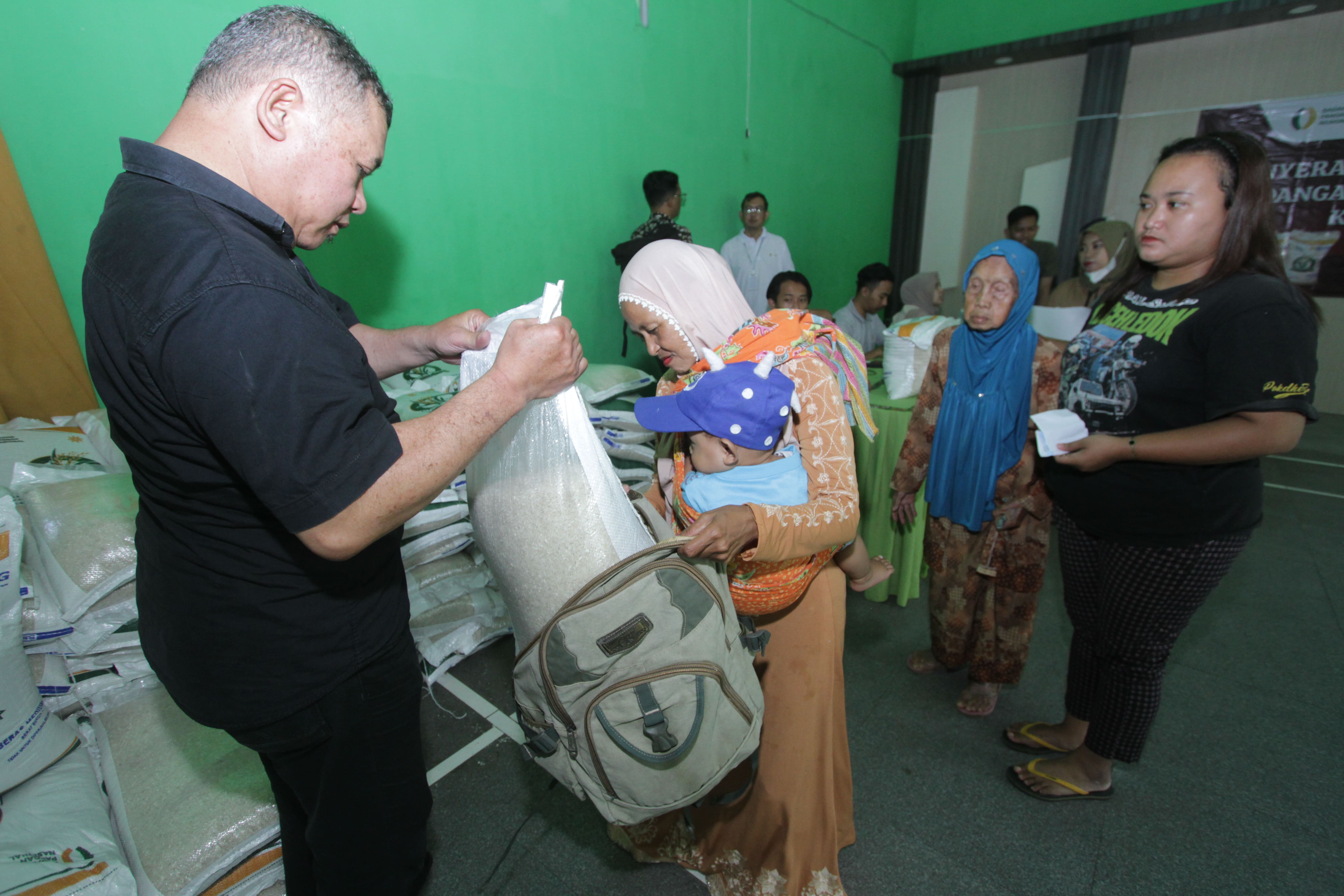 CEGAH INFLASI: Warga Kecamatan Kedungkandang antre menerima beras gratis di kantor Kelurahan Buring kemarin.