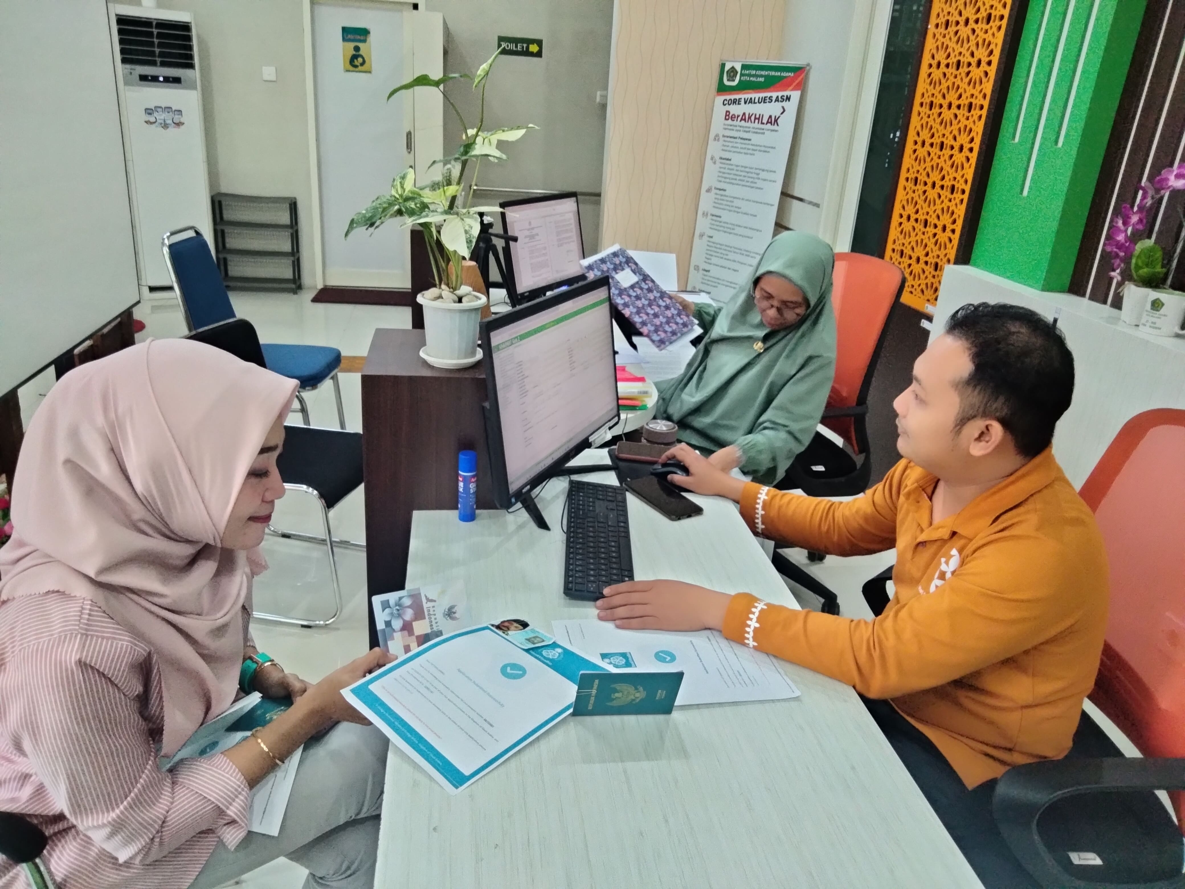 LENGKAPI PERSYARATAN: Petugas dari kantor Kemenag Kota Malang melayani jamaah yang mengurus berkas administrasi kemarin.