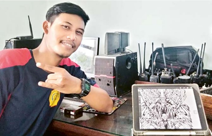 BERJIWA SENI: Yobi Utama Putra di kantor UPT Damkar Kota Malang membawa karya seninya.