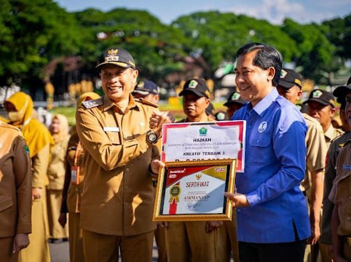 Pj Wali Kota Malang Wahyu Hidayat menyerahkan penghargaan kepada Nor Muhlas, Dirut Tugu Tirta