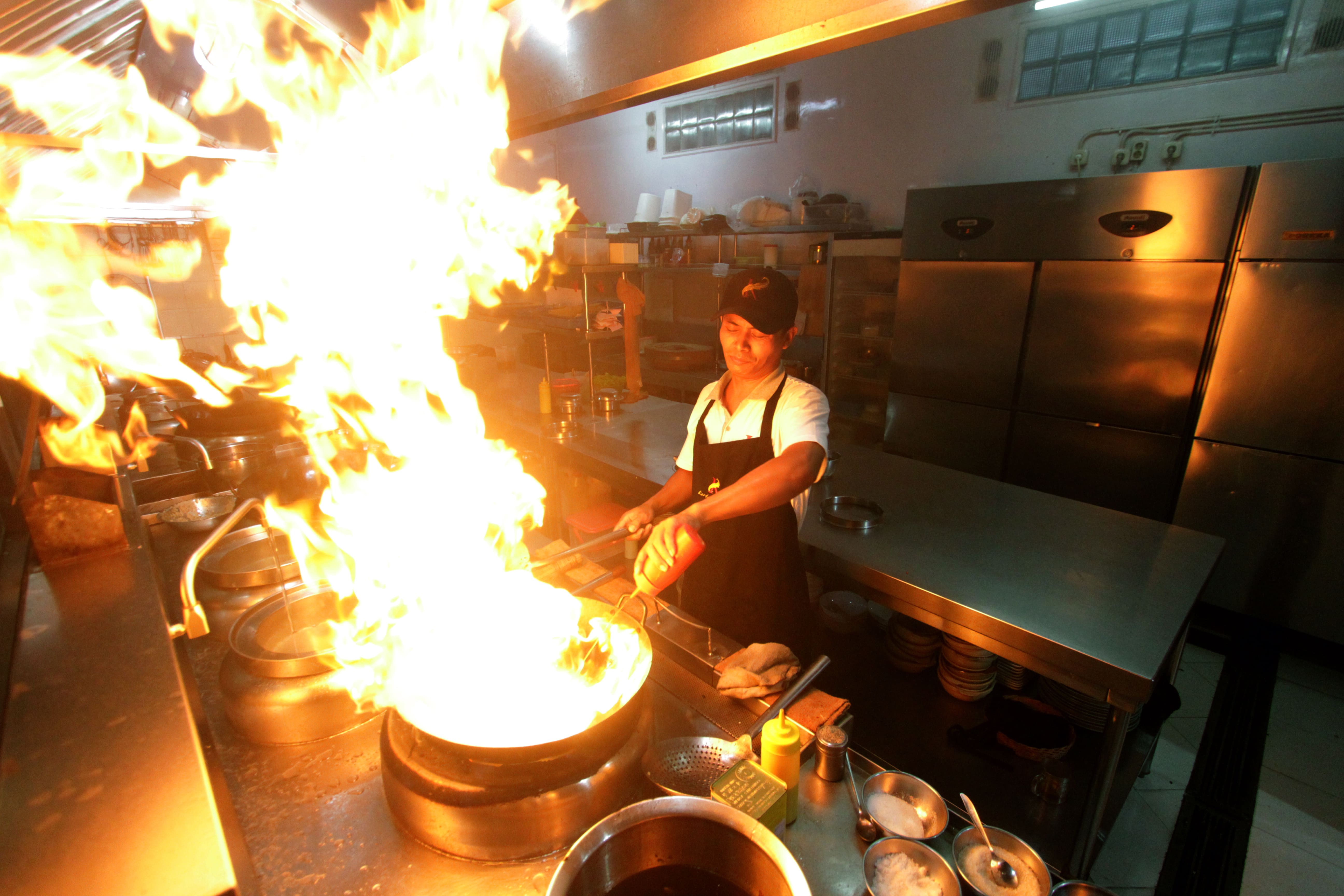SUMBANG PAD: Seorang koki memasak di salah satu restoran di Kota Malang.