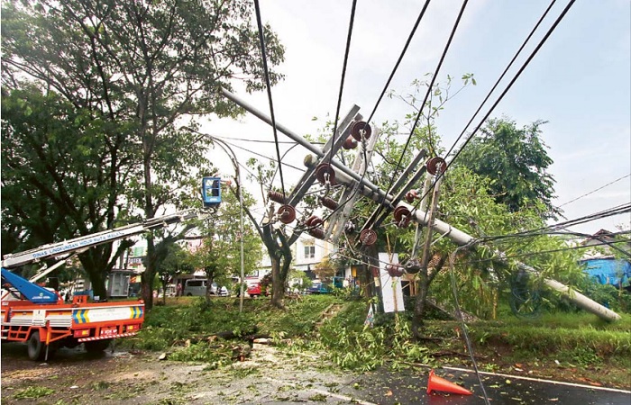 BAHAYA: Sebuah tiang listrik roboh setelah tertimpa pohon tumbang akibat hujan deras dan angin kencang di Jalan Raya Mulyorejo kemarin sore. Sekitar 100 meter dari lokasi itu juga ada tiang listrik ya