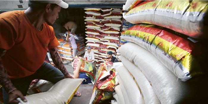 STOK MASIH AMAN: Pekerja menurunkan pasokan beras medium ke sebuah toko beras di Jalan Kyai Tamin, Kecamatan Klojen, Kota Malang, kemarin (1/3).