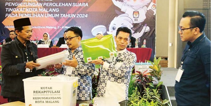 AKHIRNYA SELESAI: Panitia Pemilihan Kecamatan Kedungkandang membuka kotak rekapitulasi suara disaksikan petugas Bawaslu di Harris Hotel and Conventions, Minggu malam (3/3).