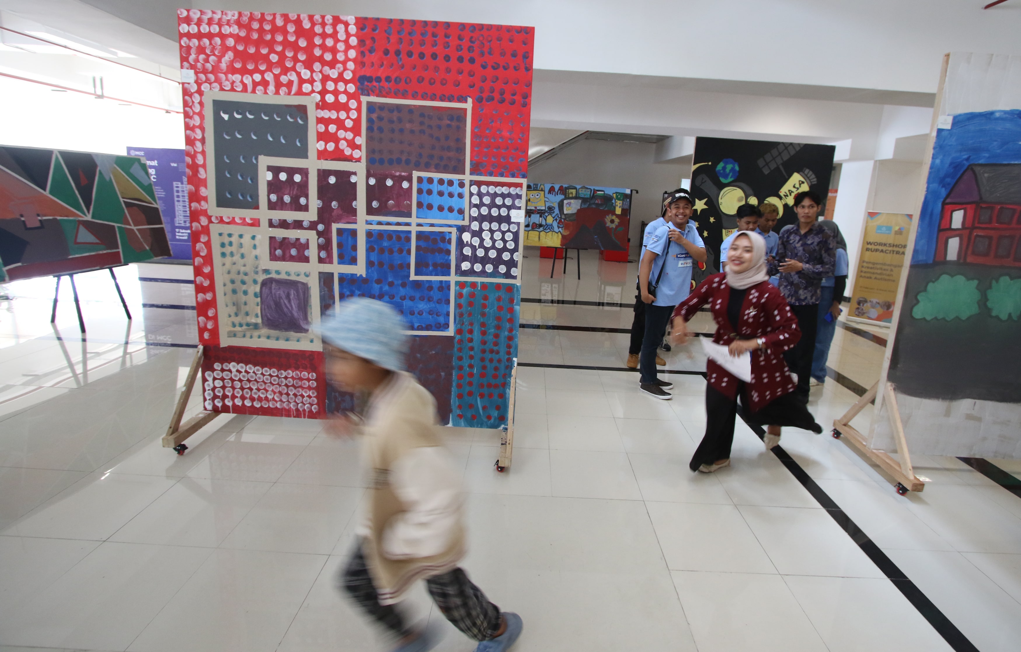BERKARYA: Salah satu anak autis berlarian usai melukis dan mewarnai di gedung Malang Creative Center (MCC) Jalan A. Yani, Blimbing, Kota Malang, kemarin (5/3).