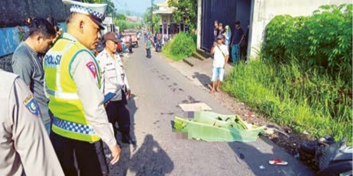 Jenazah Marni ditutup daun pisang sebelum evakuasi. Perempuan 68 tahun itu terlindas truk di Jalan Raya Desa Sumbersuko, Kecamatan Dampit, kemarin (6/3).