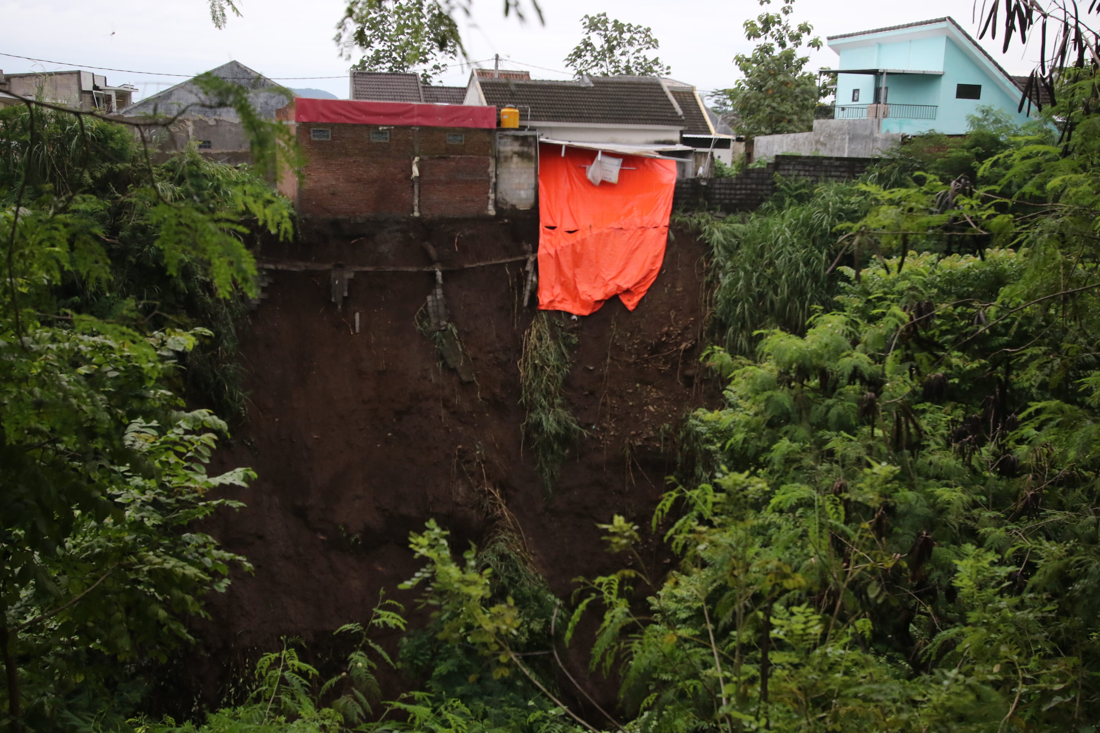BENCANA: Dua rumah di Jalan Moch. Rsyid Gang Akasia, Kelurahan Mulyorejo, Kecamatan Sukun, terdampak longsor. Satu rumah sudah ambrol di bagian dapur.