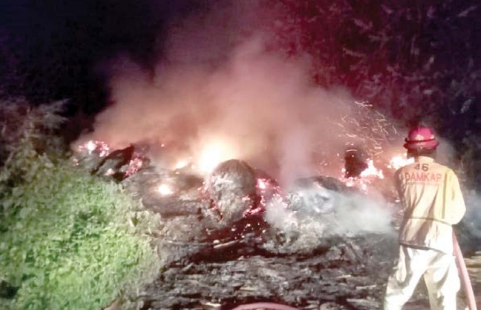 BERKOBAR: Petugas berusaha memadamkan api dalam kebakaran di tempat penampungan limbah pabrik tripleks di Desa Kasembon, Bululawang.