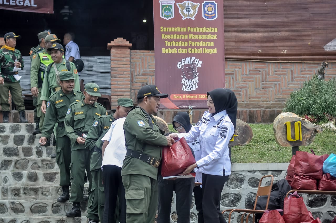 PEDULI: Satpol PP Kabupaten Malang memberikan bantuan ke personel Linmas di Dau.