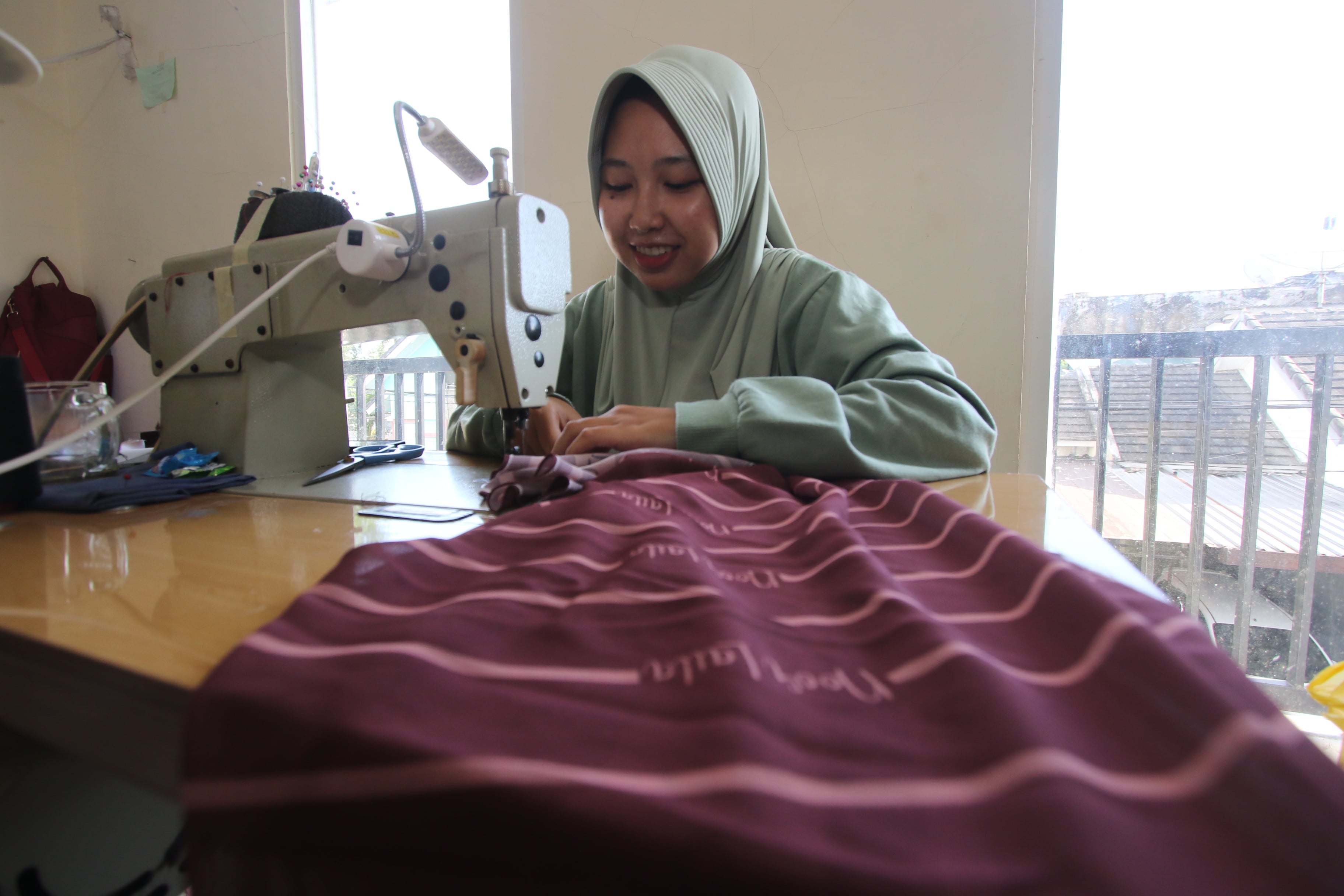 PESANAN MENINGKAT: Seorang penjahit yang bekerja di salah satu brand fashion menggarap busana untuk Ramadan hingga Lebaran.
