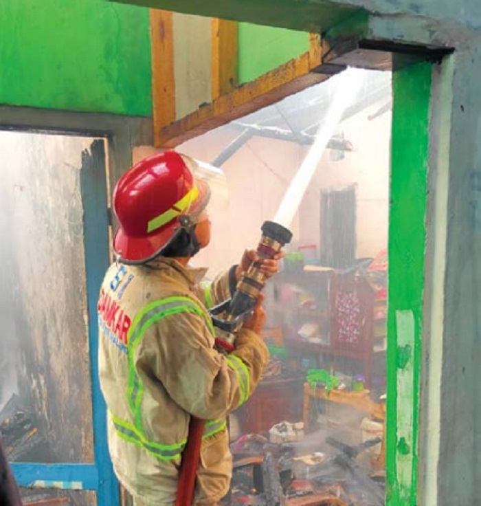 DISEMPROT: Petugas Damkar memadamkan api dalam kebakaran rumah di Kelurahan Ngadilangkung, Kecamatan Kepanjen.