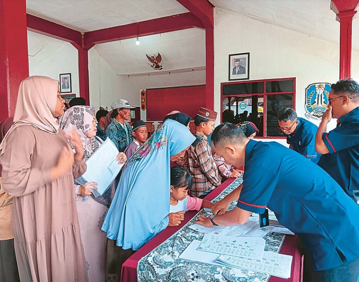 DIBERIKAN TUNAI: Penyerahan bantuan uang kepada anak yatim yang digelar di Balai Desa Jatiguwi, Kecamatan Sumberpucung.