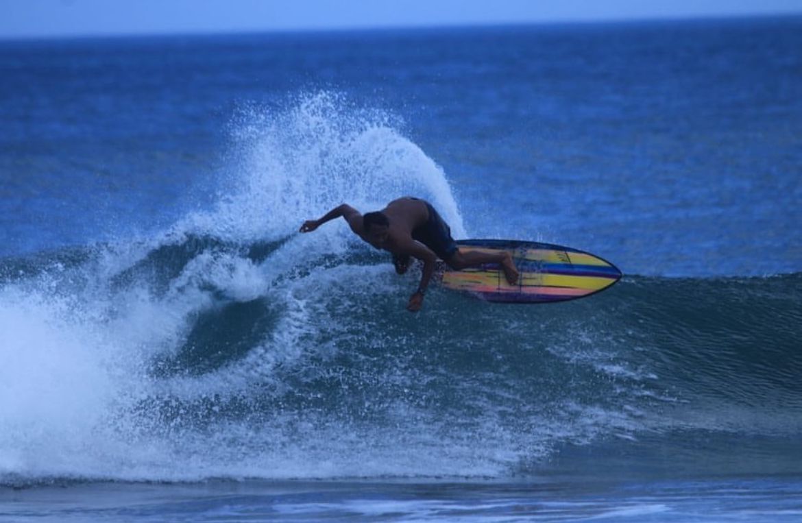 Atlet Surfing Jawa Timur Rizky Eka menahklukkan ombak Pantai Tanjung Penyu di Sitirejo, Malang Selatan