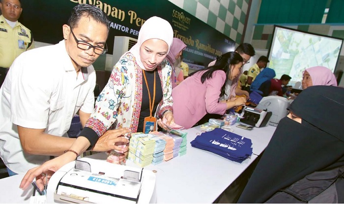 ANTUSIAS TINGGI: Petugas melayani penukaran uang baru di Gedung Kartini kemarin. Dalam sehari, BI Malang menyediakan uang baru senilai Rp 11,4 miliar.