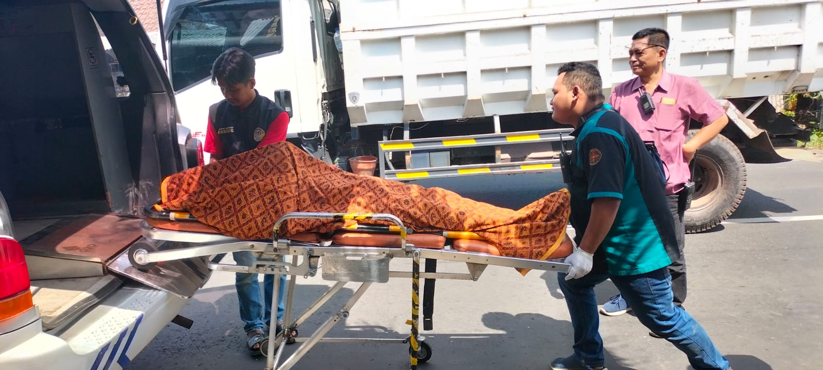 Wiwik asal Mbareng, sing wis ladub (berangkat), digotong nakes ublem (masuk) ambulans.
