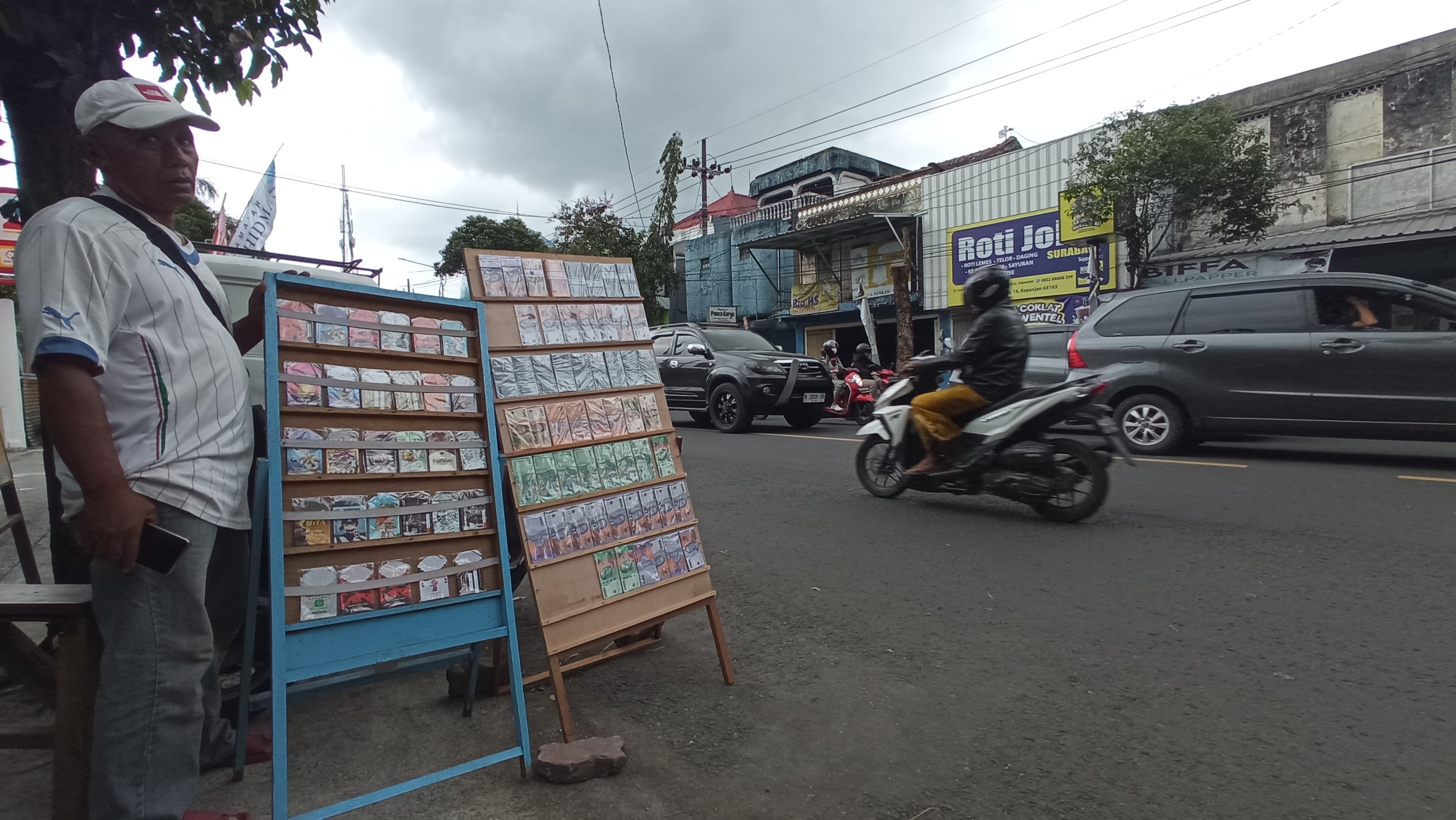MAKIN LARIS: Seorang penyedia jasa penukaran uang baru mangkal di Jalan Sultan Agung, Kepanjen. Mereka menunggu masyarakat yang membutuhkan uang baru.