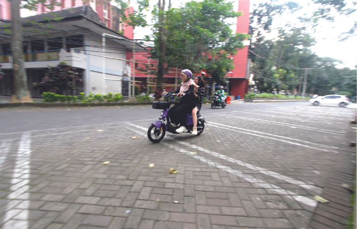 CONTOH BENAR: Dua mahasiswi menggunakan sepeda listrik di area kampus Universitas Brawijaya (UB). Aturan penggunaannya dibatasi di beberapa tempat.