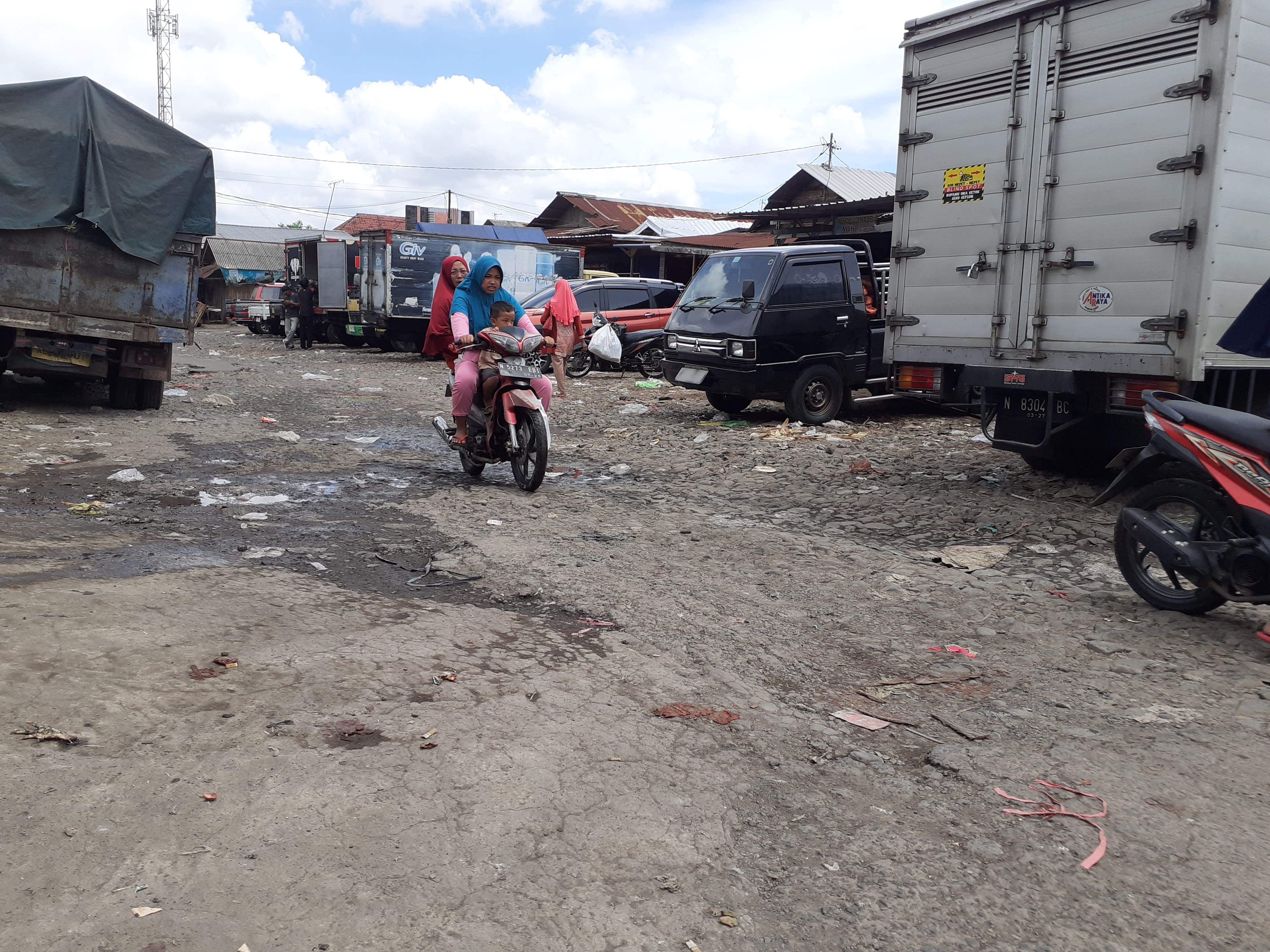 BUTUH PERHATIAN: Warga melintasi di area Pasar Dampit kemarin. Aspal sebagian jalan sudah mengelupas