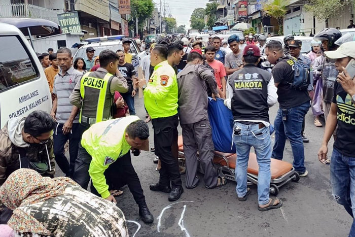 LAKA TUNGGAL: Polisi bersama warga mengevakuasi jenazah korban untuk dibawa ke RSUD Dr Syaiful Anwar kemarin.