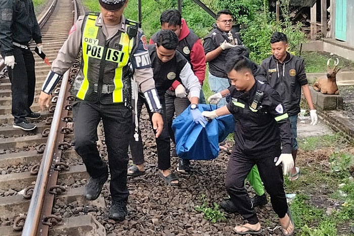 Polisi dan relawan mengevakuasi jenazah Juanda Fernando yang tertabrak KA Arjuno Ekspres di petak antara Stasiun Malang dengan Stasiun Blimbing, Rampal Celaket