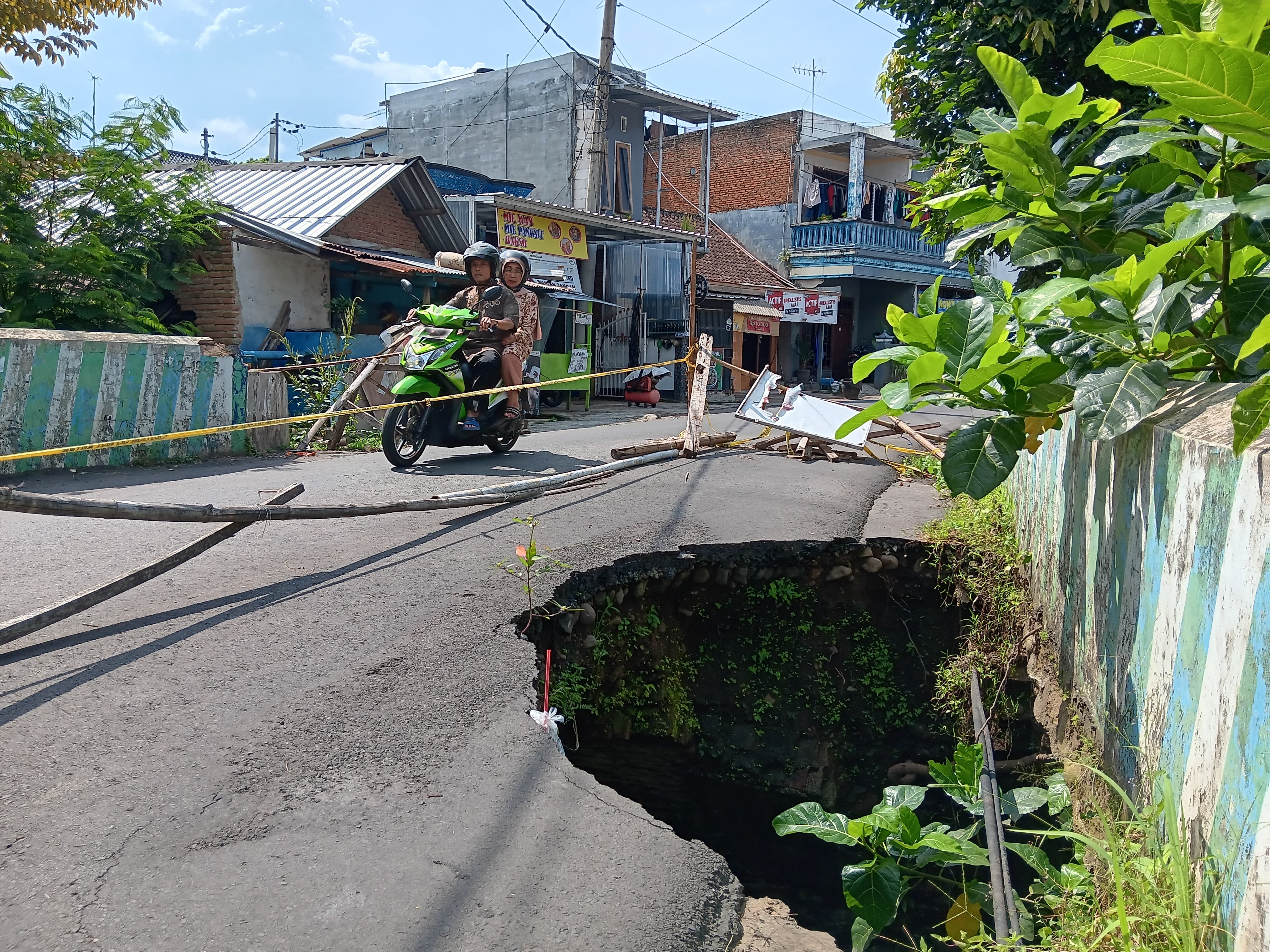 BUKA TUTUP: Pengendara yang melintasi jembatan penghubung dua dusun di Desa Landungsari, Kecamatan Dau harus rela bergantian karena sebagian ruas ditutup.