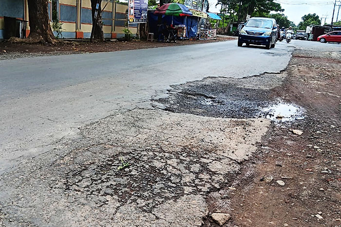 Beberapa kendaraan melintasi Jalur Kepanjen-Pagak arah pantai Malang selatan kemarin (19/4). Beberapa ruas berlubang akibat aspal mengelupas.