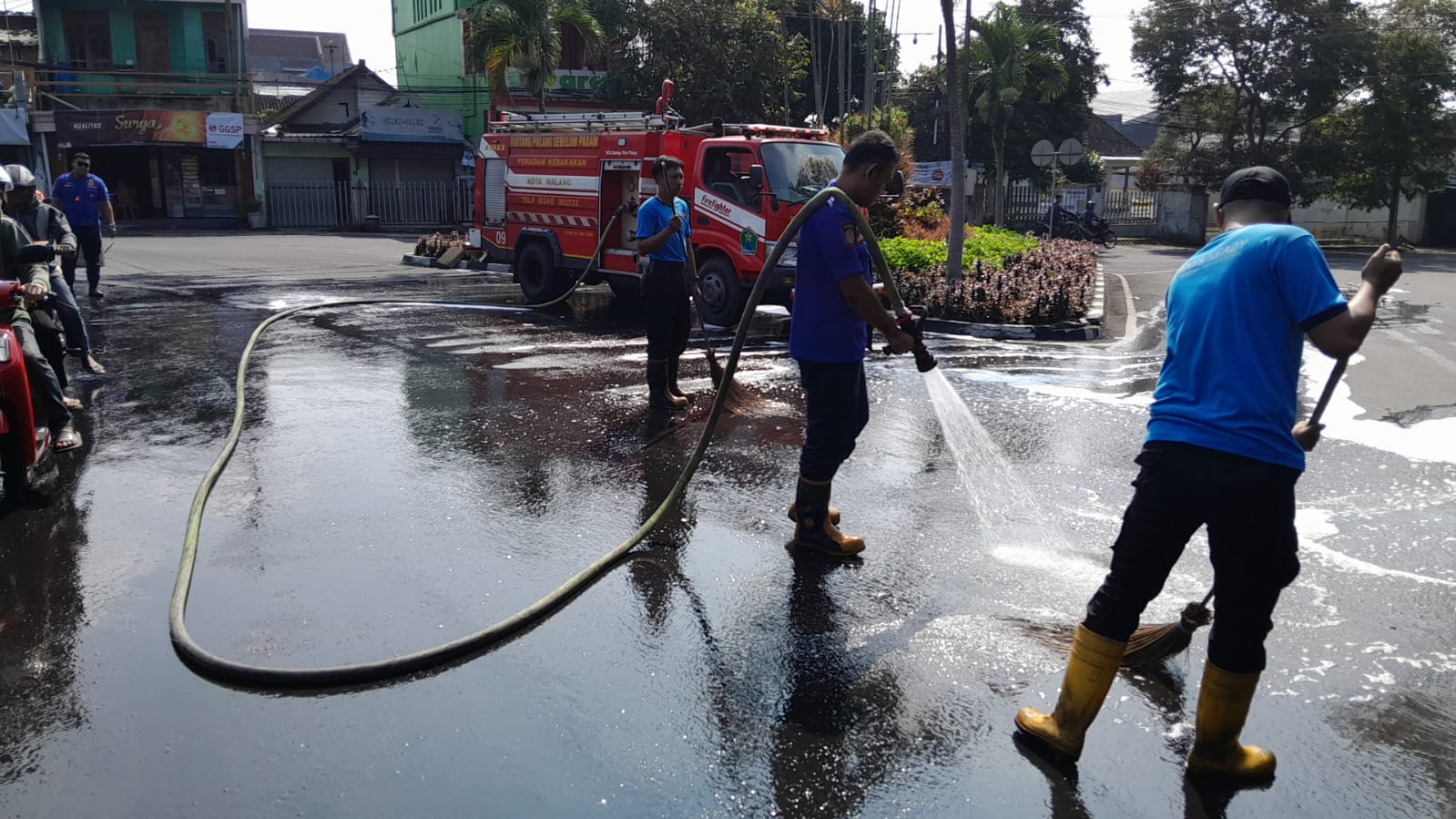 Petugas Damkar Kota Malang membersihkan tumpahan solar di Jalan Tumenggung Suryo kemarin (21/4). Tumpahan itu memanjang hingga 16 meter dan mengakibatkan satu pemotor terpeleset.