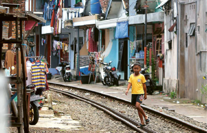 PADAT: Deretan rumah warga berdiri tak jauh dari rel kereta api di Jalan Sartono, Kecamatan Klojen.