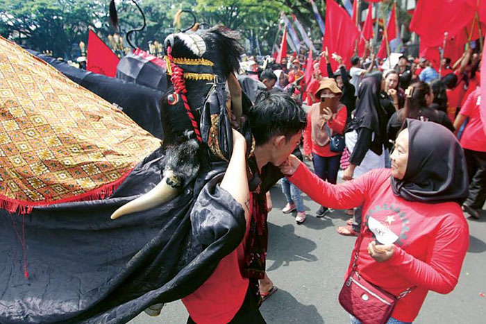 Aksi bantengan mberot mengiringi demo peringatan Hari Buruh Internasional di Balai Kota Malang kemarin (1/5). Mereka menuntut pencabutan UU Cipta Kerja.