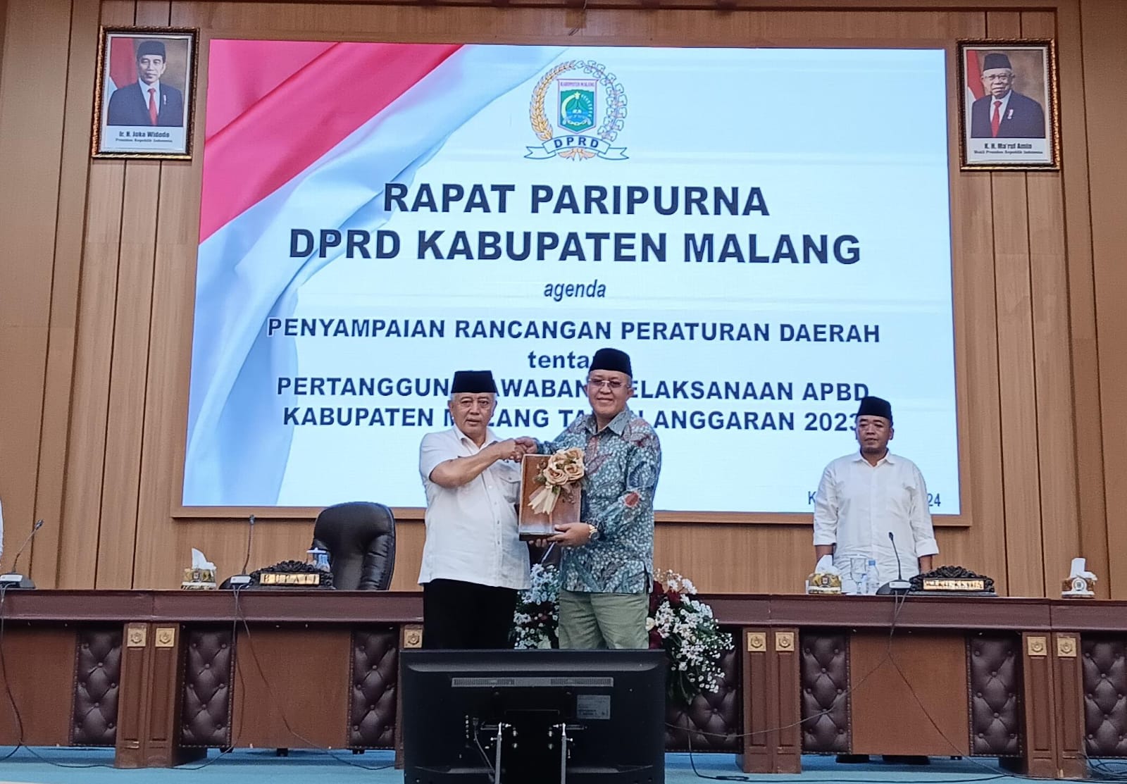 PARIPURNA: Bupati Malang H M. Sanusi (kiri) menyerahkan draf raperda kepada Wakil Ketua I DPRD Kabupaten Malang H KHoliq kemarin.
