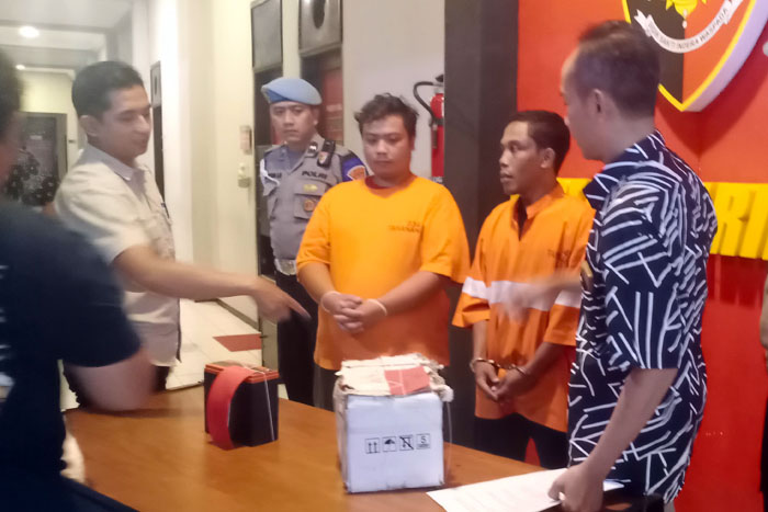 DICIDUK PETUGAS: Fiqih dan Andik, dua tersangka pencurian baterai motor listrik saat di Mapolresta Malang Kota kemarin (7/5).