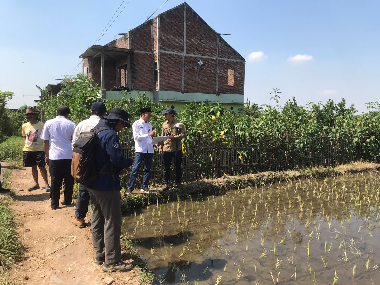 UKUR LAHAN: Aparat Desa Landungsari menyakiskan pengukuran lahan untuk pelebaran jalan di Dusun Bendungan Desa Landungsari (8/5)