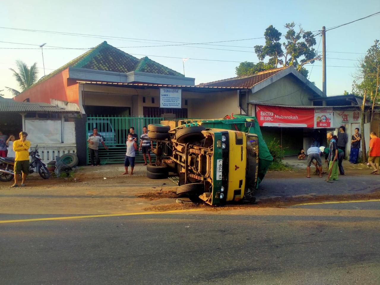 LAKA LANTAS: Warga sekitar bersiap mengevakuasi truk yang terguling di Jalan Raya Ngebruk, Kecamatan Sumberpucung, kemarin pagi (12/5)