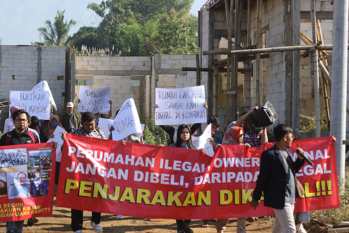 Banner dan kertas berisi kalimat kecaman dibentangkan user perumahan D&rsquo;Graha Artha, kemarin. Diduga perumahan di Singosari Malang itu bermasalah sehingga pembangunan molor