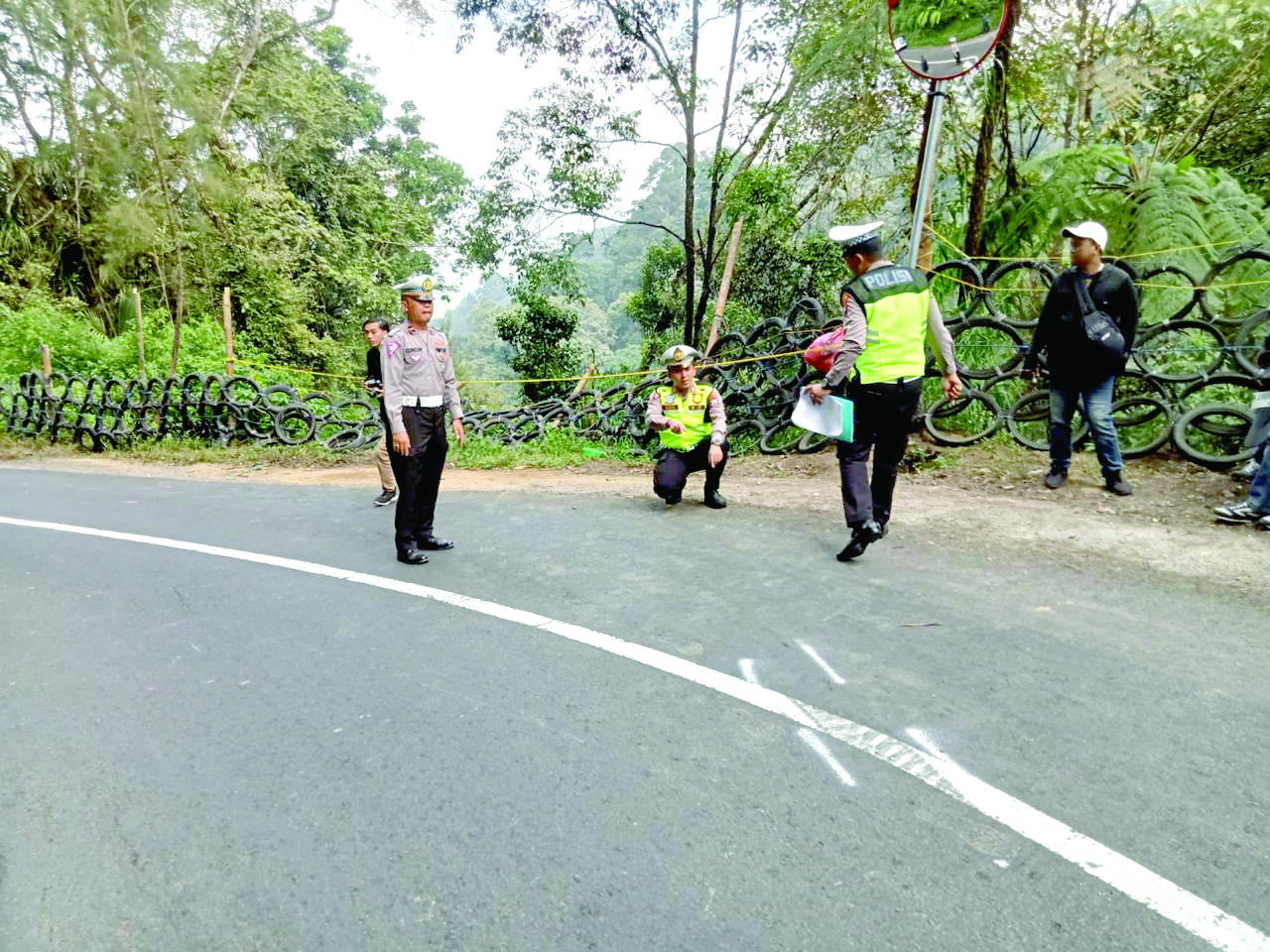 JALUR BERBAHAYA: Personel Satlantas Polres Malang menandai titik rawan kecelakaan yang sebelumnya memakan korban jiwa.