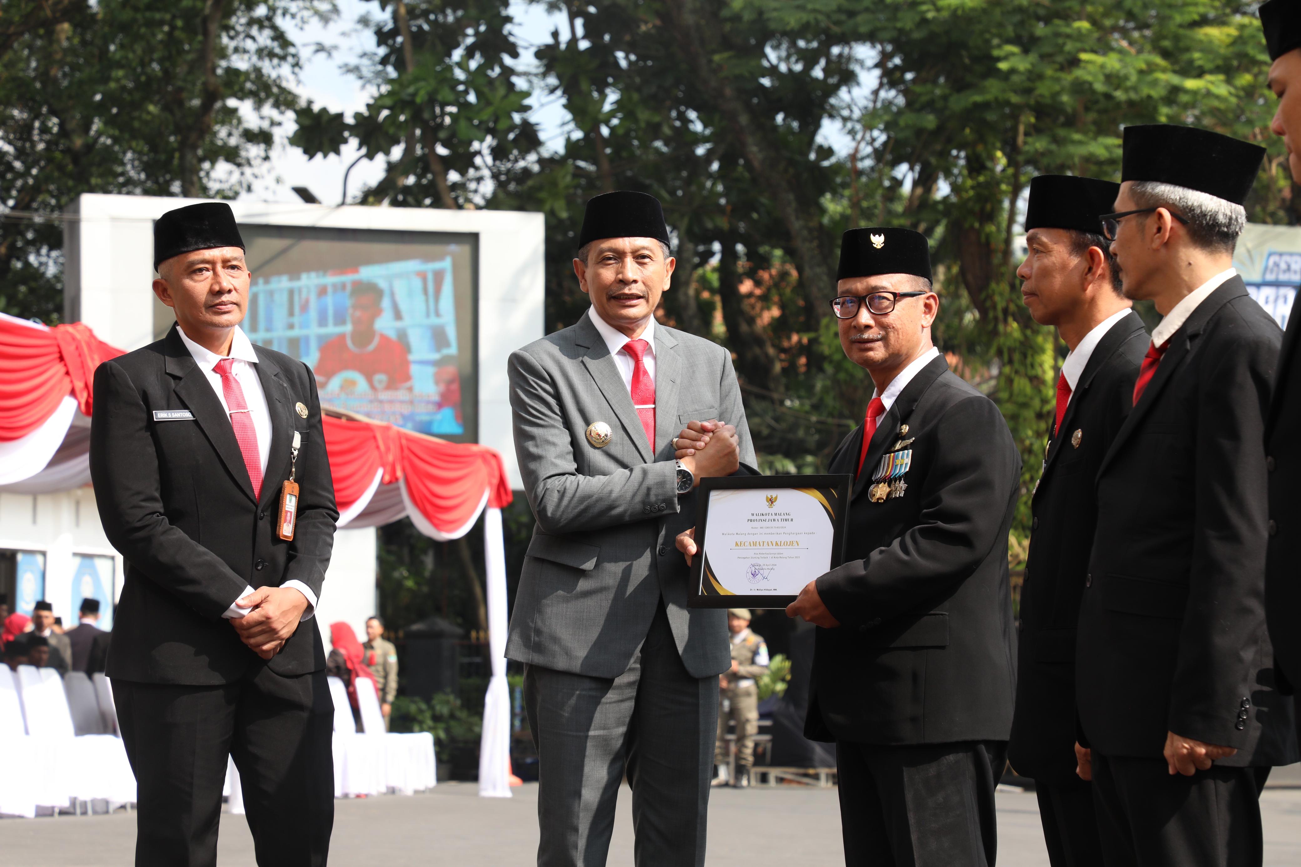 Pj Wali Kota Malang Wahyu Hidayat memberikan penghargaan untuk Kecamatan Klojen yang berprestasi dalam penanganan stunting