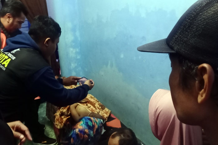 Polisi memeriksa dan mendokumentasikan salah satu bocah yang meninggal akibat tenggelam di Sungai Lo Madyopuro, Malang