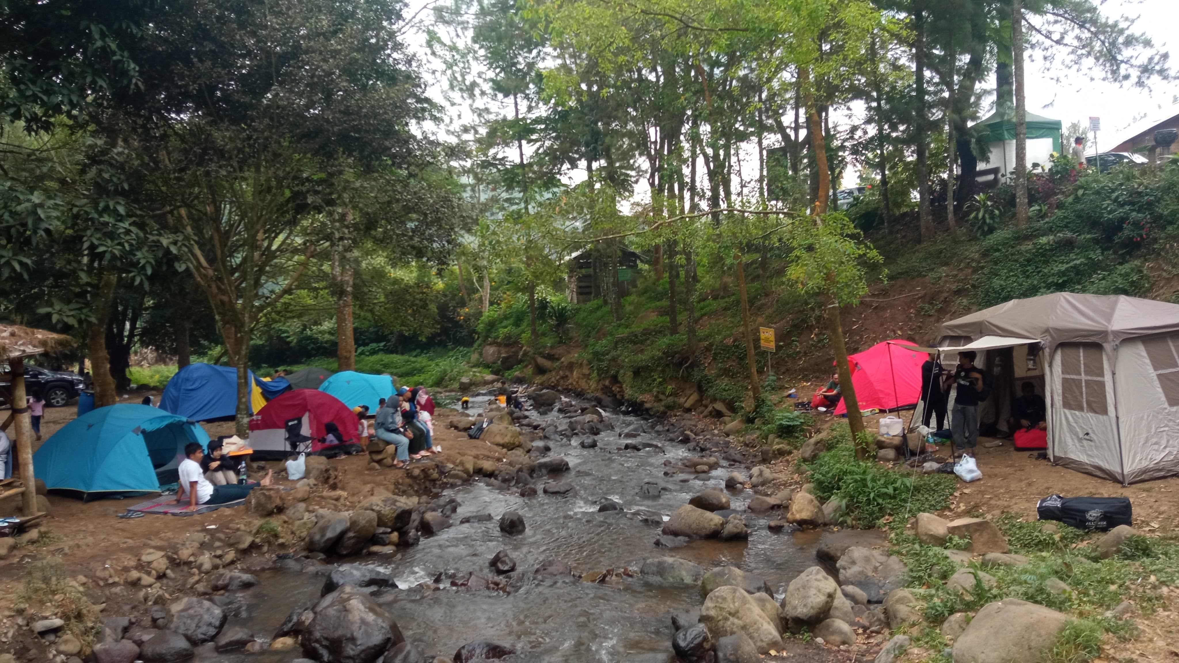 TARIF MURAH: Para wisatawan mendirikan tenda di tepi sungai area Bumi Perkemahan Bedengan, Desa Selorejo, Kecamatan Dau, Kabupaten Malang.