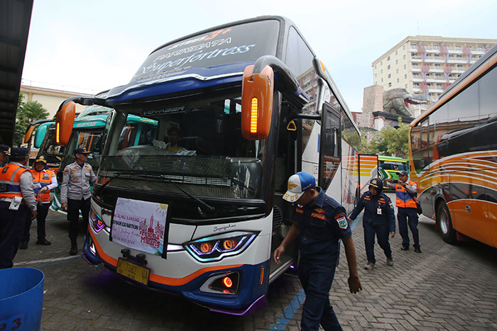 ANTISIPASI: Petugas Dishub Kota Batu dan satuan dari Terminal Tipe A Arjosari memeriksa kondisi bus wisata di Jatim Park 3 kemarin.