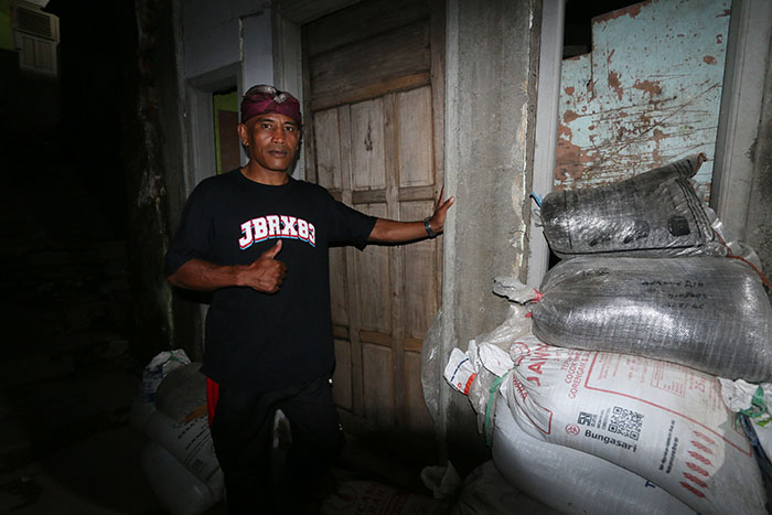 BUTUH ULURAN TANGAN: Wicahyono alias Dobrak Arter menunjukkan rumahnya yang rusak di Tanjungrejo, Kecamatan Sukun, Kota Malang kemarin.