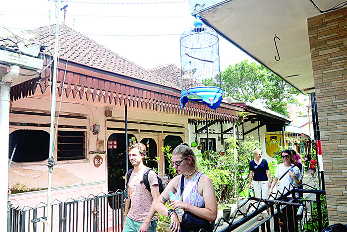 Bule sedang berjalan di kampung heritage Kajoetangan Malang