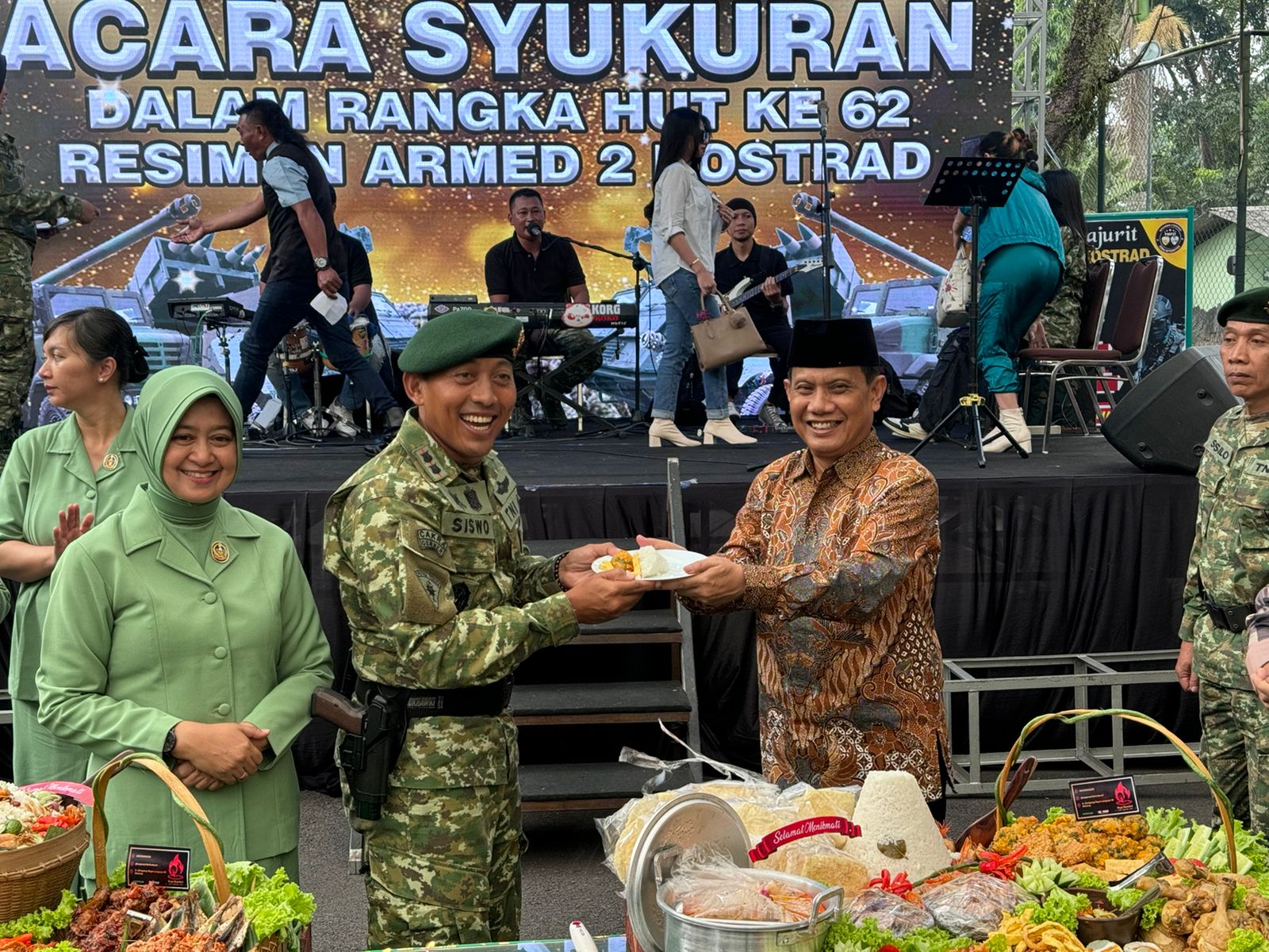 KEBERSAMAAN: Anggota DPRD Jatim Gunawan Wibisono HS (kanan) menerima potongan tumpeng dari Komandan Resimen Letkol Arm Siswo Budiarto kemarin.