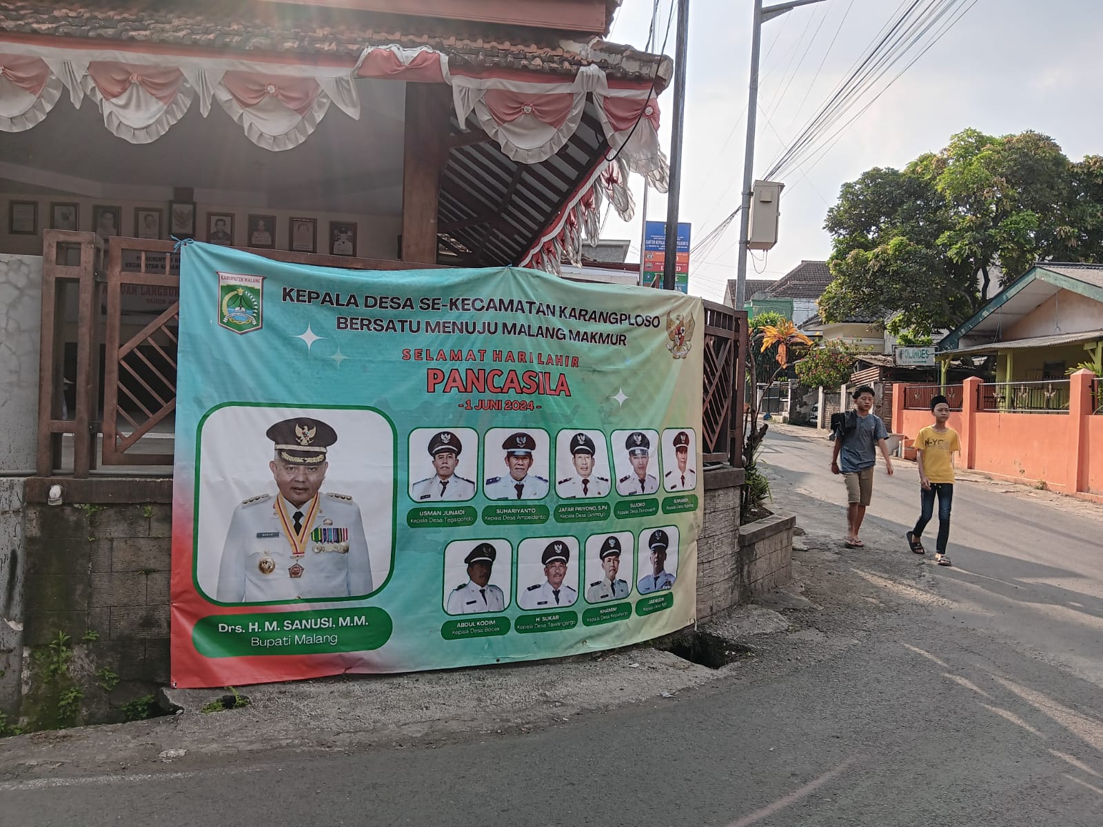 PESAN POLITIK: Poster berisi foto calon petahana H M. Sanusi bersama Kepala Desa (Kades) se-Kacamatan Karangploso terpasang di depan kantor Desa Ampeldento kemarin (18/6).