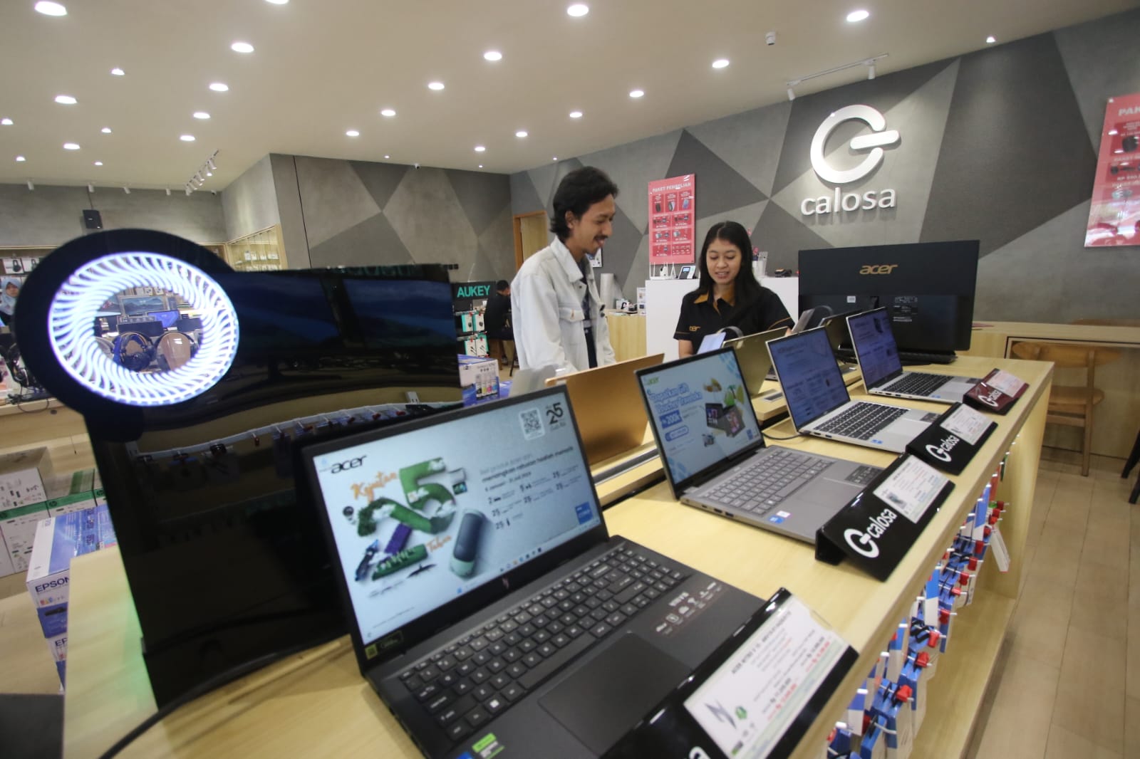 SELALU JADI BURUAN: Staf promosi Calosa laptop & gadget store melayani customer yang bertanya tentang produk Acer, belum lama ini.