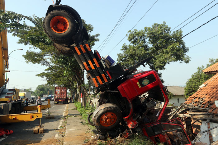 TABRAK DUA MOTOR: Evakuasi truk bernopol L 9524 UO di Jalan Raya Malang-Surabaya, Kabupaten Pasuruan dimulai menjelang pukul 14.00, kemarin.