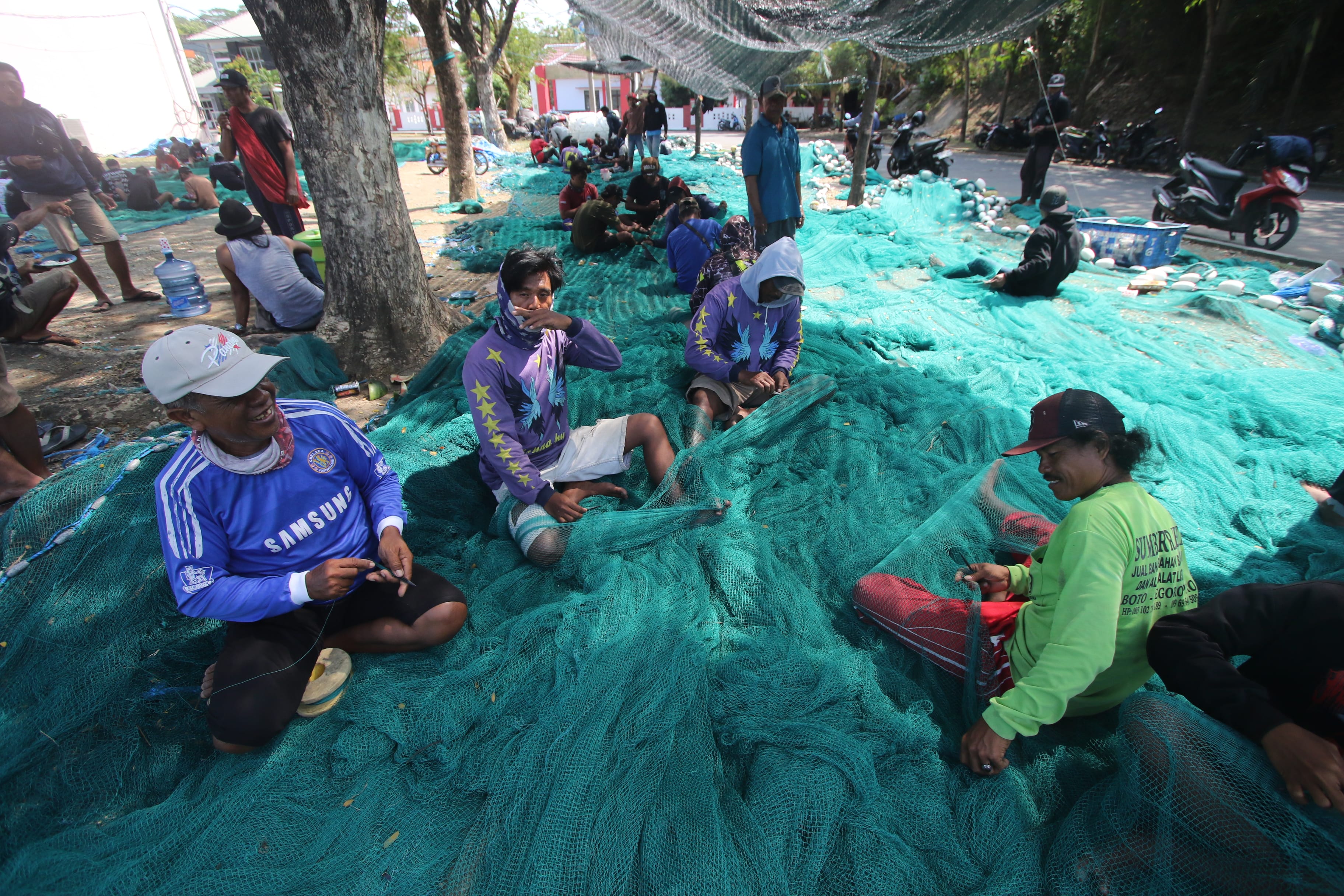 RUTIN: Para nelayan di Pantai Sendangbiru, Desa Tambakrejo, Kecamatan Sumbermanjing Wetan, Kabupaten Malang memperbaiki jaring pukat cincin.