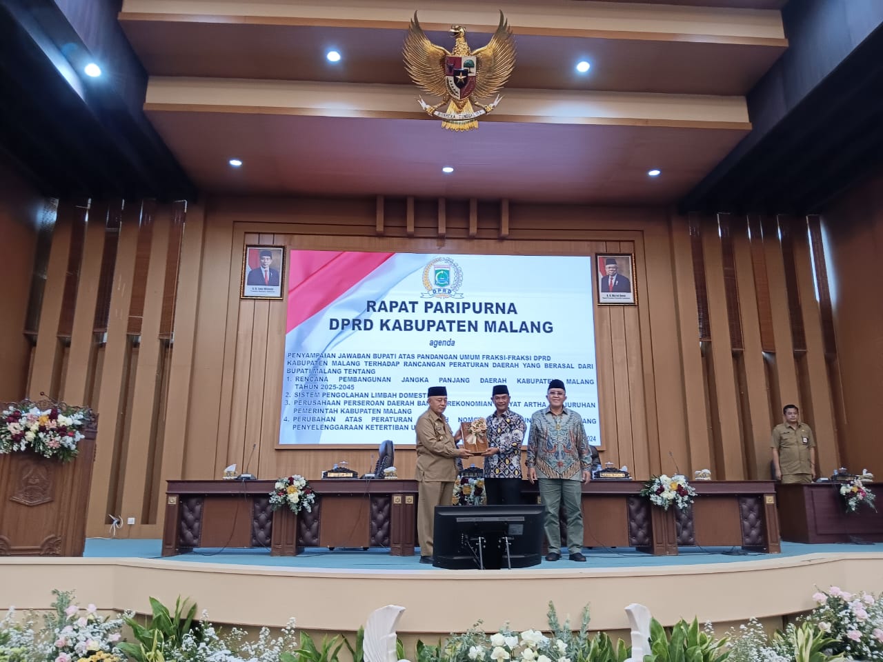 BAHAS PEMBANGUNAN: Bupati Malang H M. Sanusi (kiri) dan Ketua DPRD Kabupaten Malang Darmadi (tengah) memegang dokumen hasil rapat paripurna kemarin (24/6).
