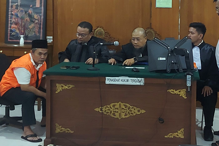 Lilik Darmanto (kiri) dan Idaman Gea (kanan) berdiskusi dengan kuasa hukumnya setelah mendengarkan putusan 4,5 tahun penjara yang dibacakan hakim Pengadilan Negeri Malang kemarin (24/6).&nbsp;